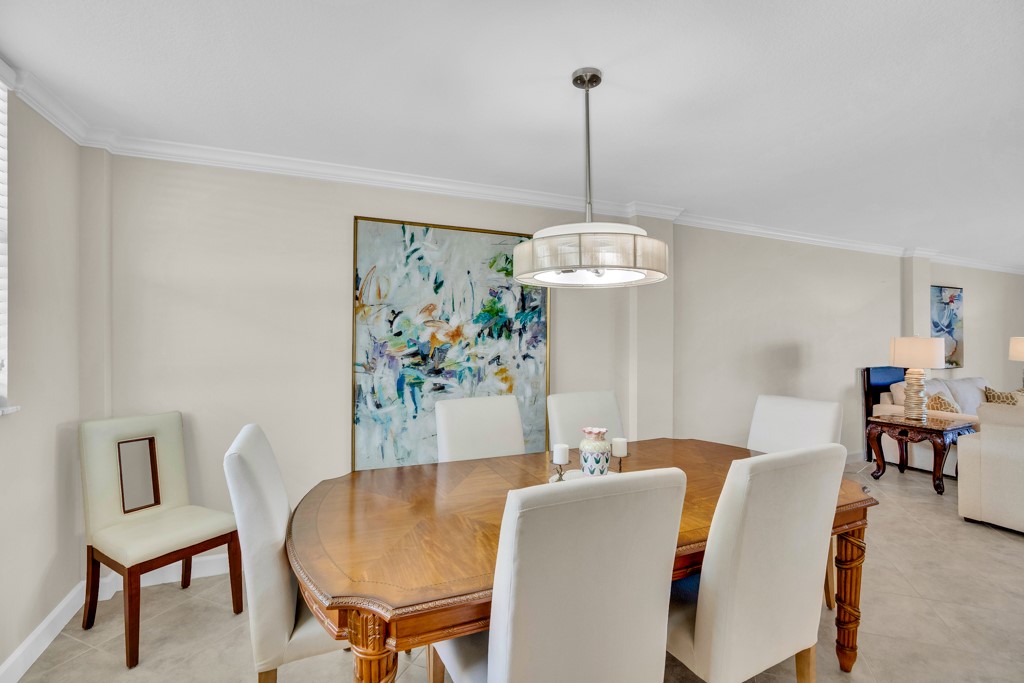 4601 Florida A1A, Unit 405 Vero Beach, FL 32963 - Photo 16 of 36 a view of a dining room with furniture a chandelier and wooden floor