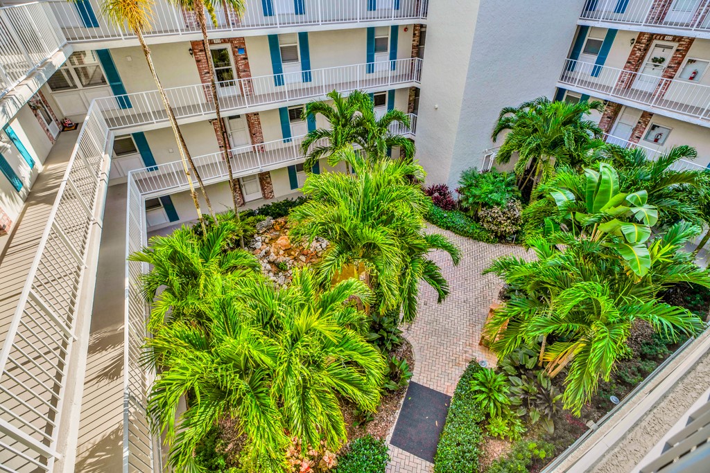 4601 Florida A1A, Unit 405 Vero Beach, FL 32963 - Photo 9 of 36 a flower garden with a building in the background