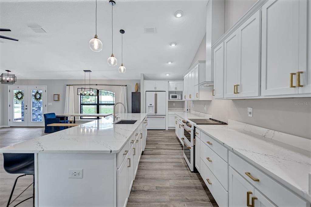 13362 Downy Woodpecker Road Weeki Wachee, FL 34614 - Photo 8 of 26 a large kitchen with stainless steel appliances lots of counter space and a sink