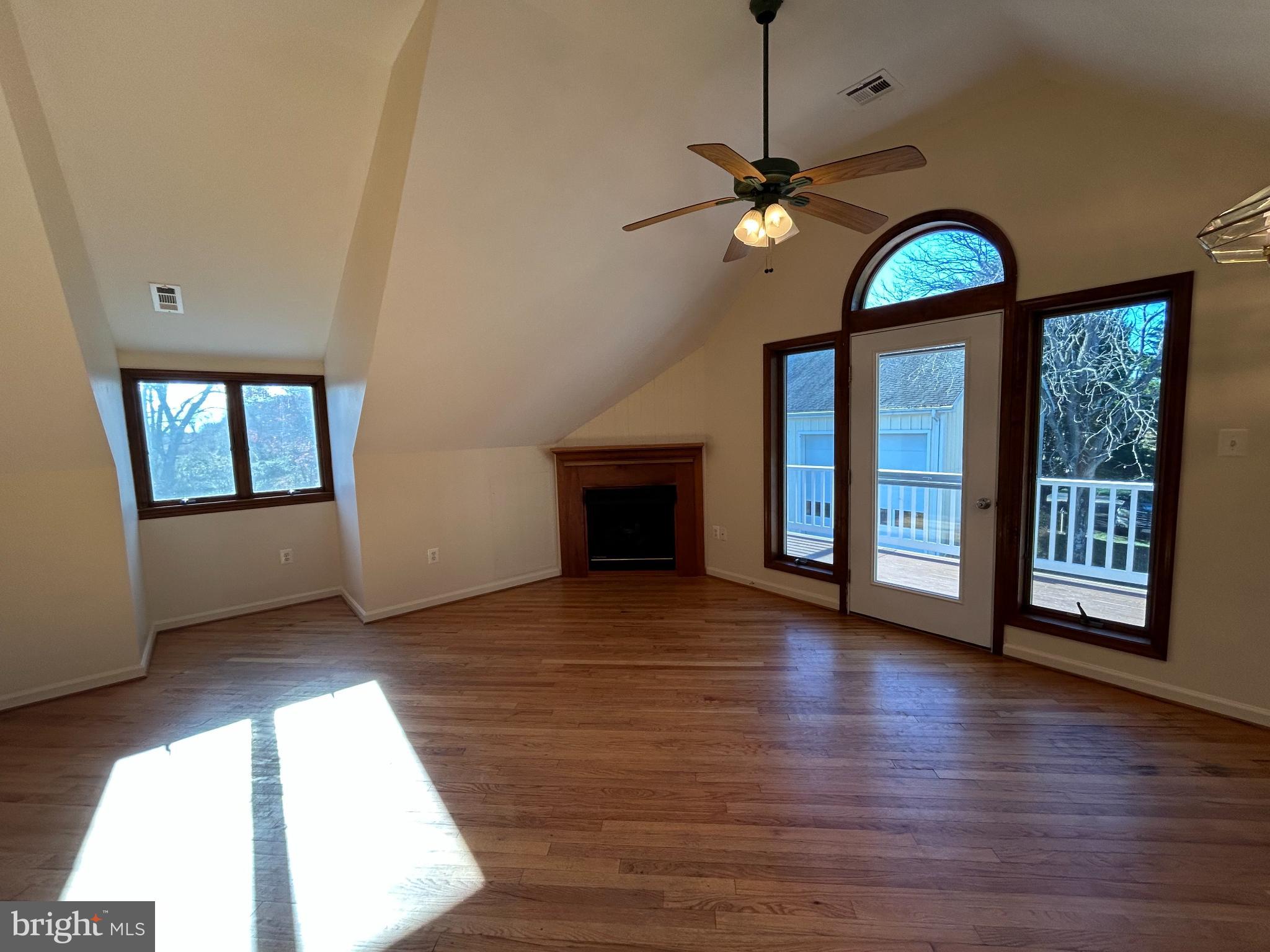 a view of a livingroom with wooden floor staircase and a fireplace