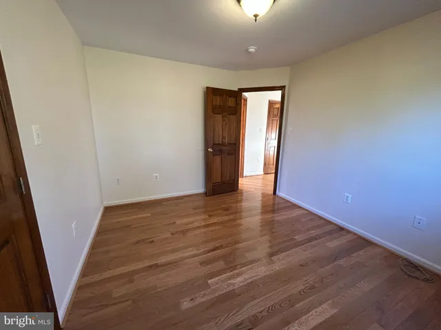 an empty room with wooden floor and sliding door