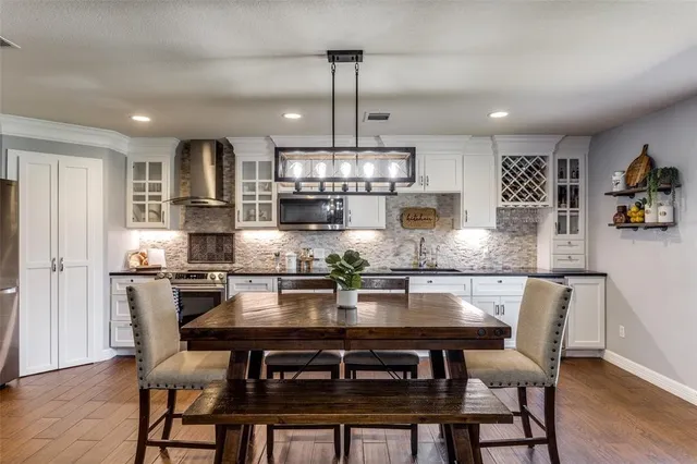 a kitchen with stainless steel appliances granite countertop a kitchen island a stove and a cabinets