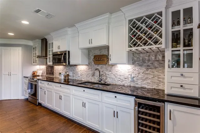 a kitchen with stainless steel appliances granite countertop a sink a stove and a microwave