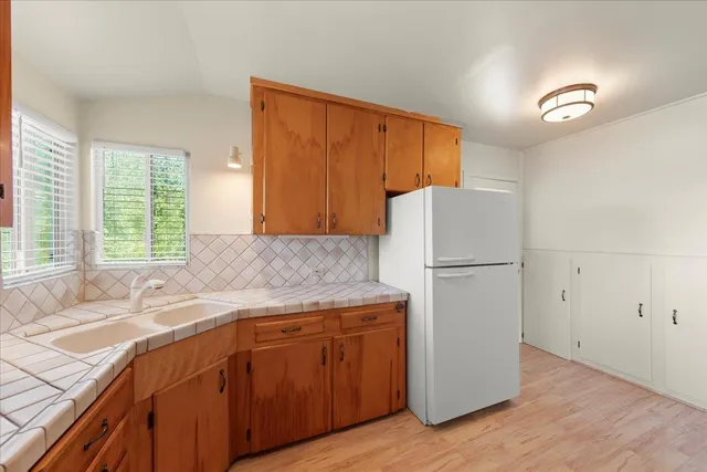 a kitchen with a refrigerator sink and cabinets