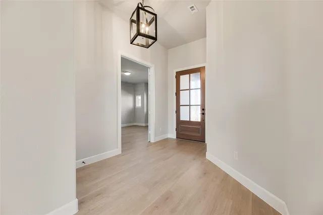a view of a hallway with wooden floor and a window