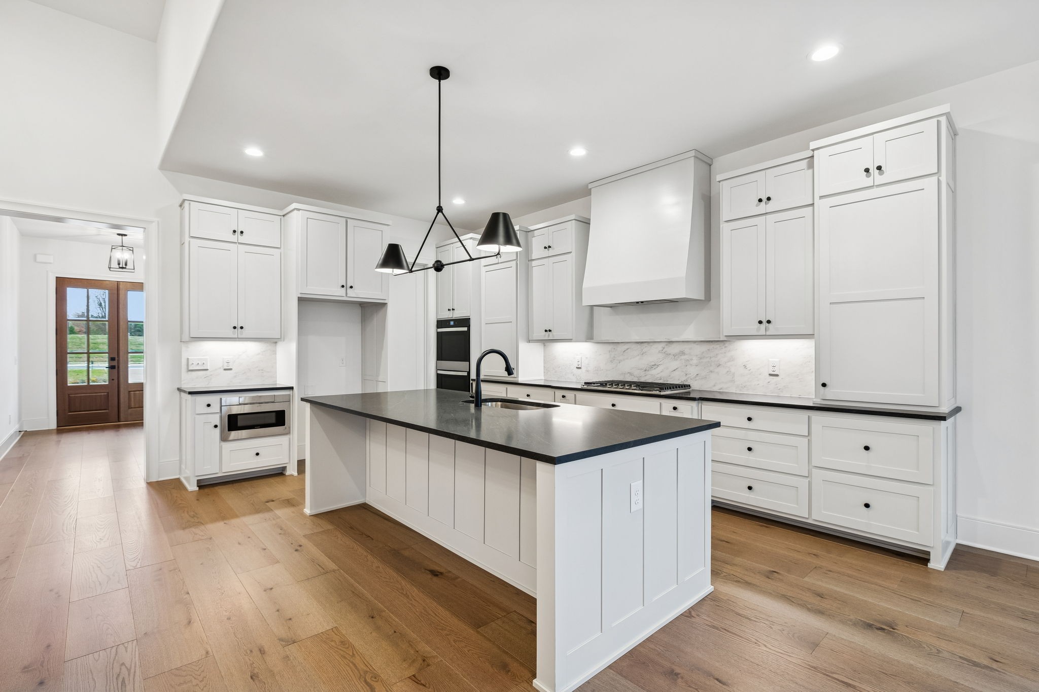209 Bellsford Road Gallatin, TN 37066 - Photo 25 of 68 a large kitchen with stainless steel appliances kitchen island granite countertop a stove a sink and white cabinets with wooden floor