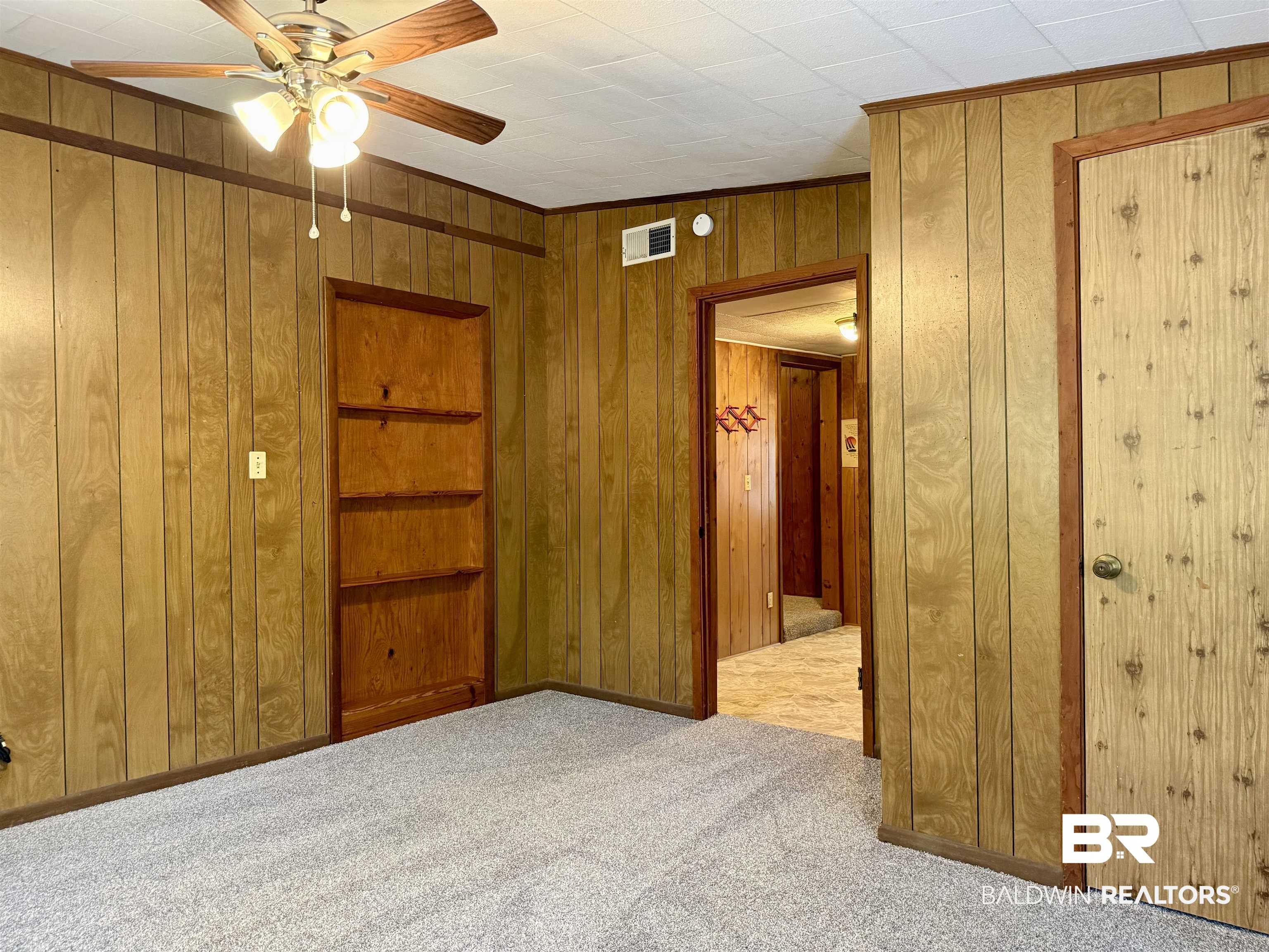 826 West Side Road Castleberry, AL 36432 - Photo 24 of 34 Unfurnished bedroom featuring wooden walls, light colored carpet, and ceiling fan