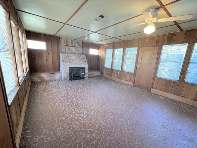 a view of empty room with fireplace and windows