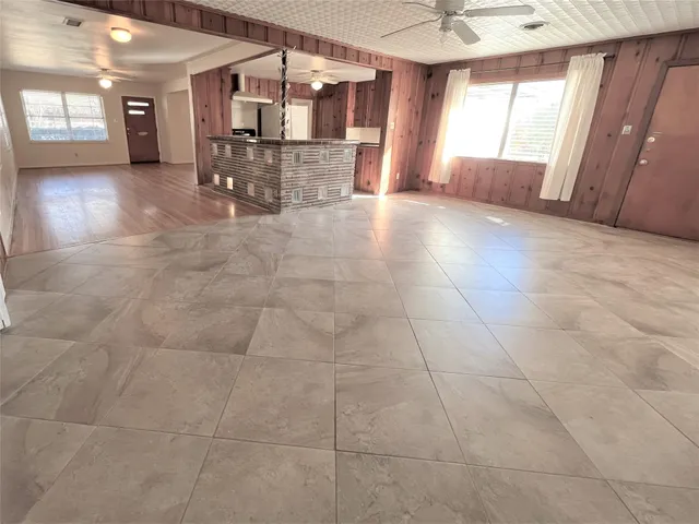 a view of a hallway with wooden floor and a kitchen