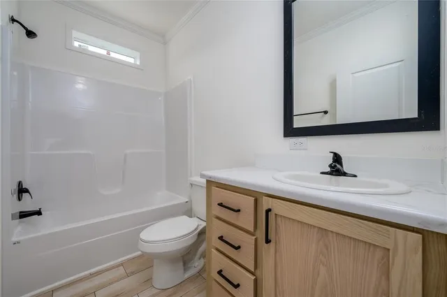 a bathroom with a granite countertop toilet sink a mirror and shower