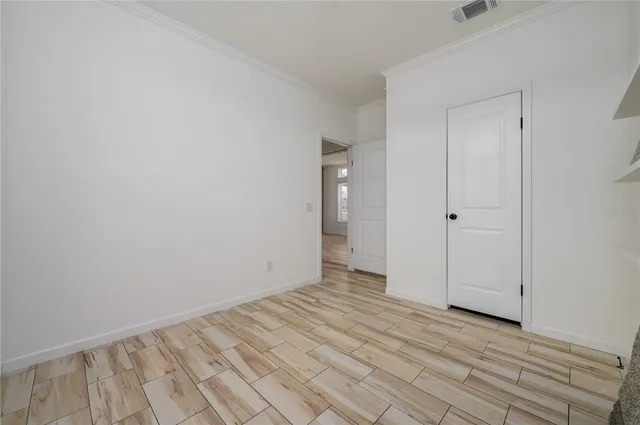 a view of an empty room with wooden floor
