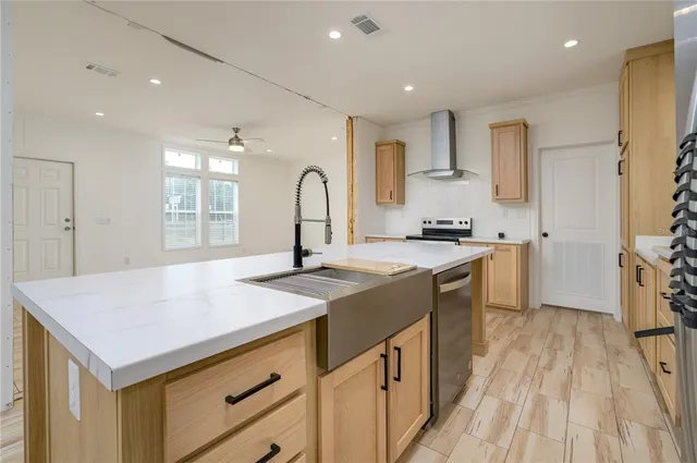 a kitchen with kitchen island a sink stove and refrigerator