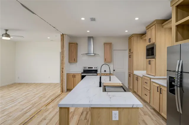 a kitchen with stainless steel appliances granite countertop a refrigerator a stove and a wooden floors