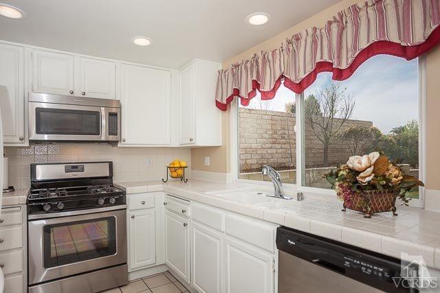 4347 Laurelhurst Road Moorpark, CA 93021 - Photo 9 of 23 a kitchen with stainless steel appliances a sink a stove and cabinets