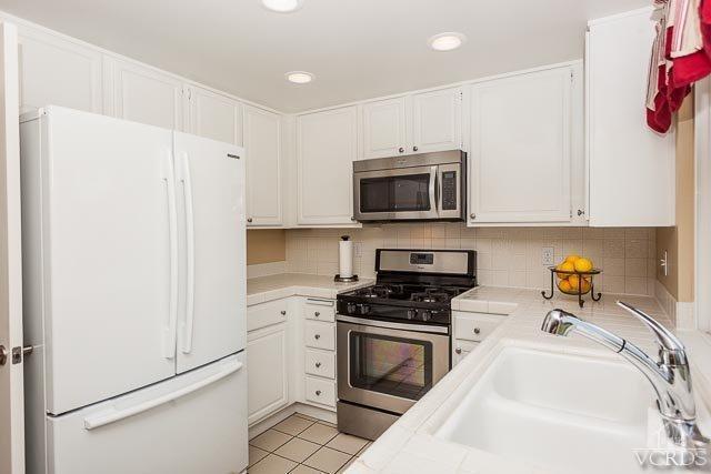 4347 Laurelhurst Road Moorpark, CA 93021 - Photo 10 of 23 a kitchen with granite countertop a sink a stove top oven and cabinetry