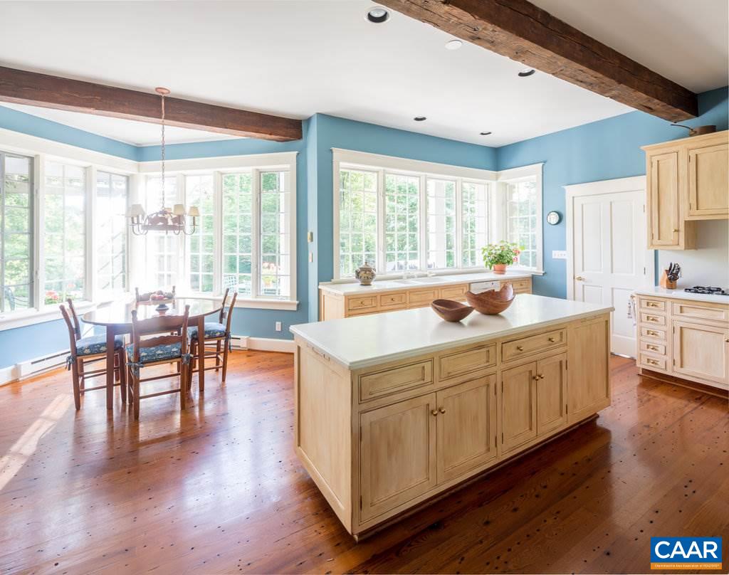 4054 Garth Road Crozet, VA 22932 - Photo 20 of 50 a open kitchen with cabinets a sink a dining table and chairs with wooden floor
