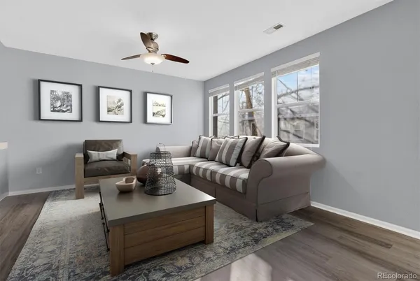a view of a livingroom with wooden floor and a ceiling fan