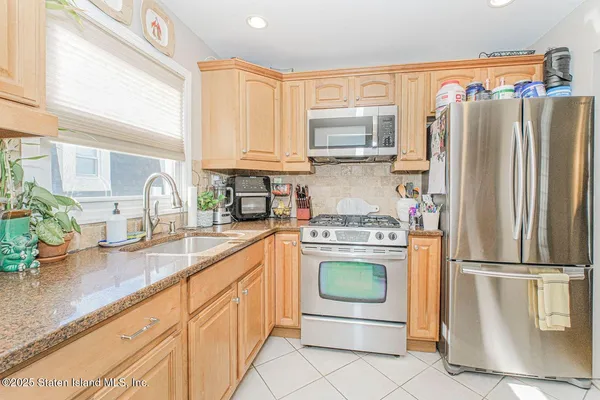a kitchen with granite countertop a refrigerator stove and sink