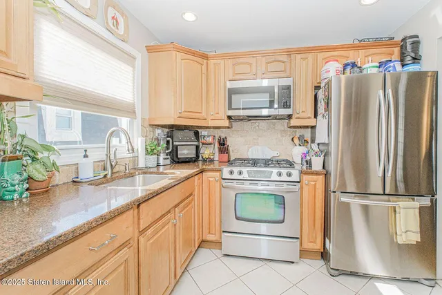 a kitchen with granite countertop a refrigerator stove and sink