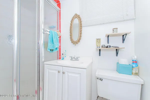 a bathroom with a sink vanity mirror and toilet