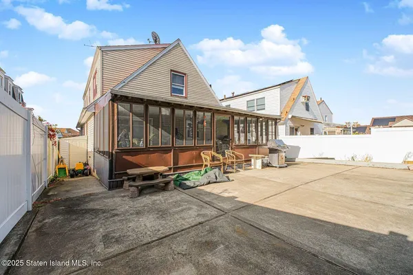 a backyard of a house with barbeque oven table and chairs