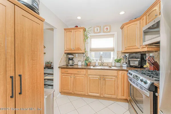 a kitchen with stainless steel appliances a sink cabinets and a window