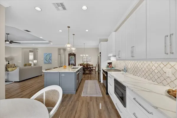 a kitchen with stainless steel appliances granite countertop a stove a sink a dining table and chairs