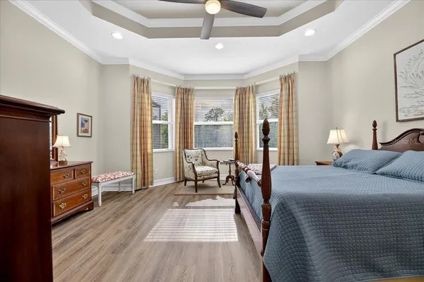 a spacious bedroom with a bed and wooden floor