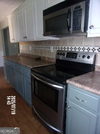 a kitchen with granite countertop a stove and a microwave