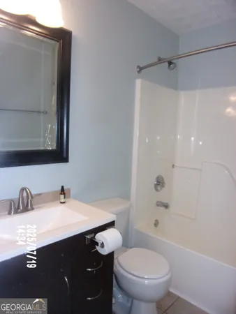 a bathroom with a sink vanity mirror and toilet