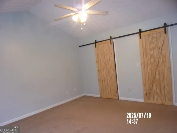 an empty room with a ceiling fan and a window