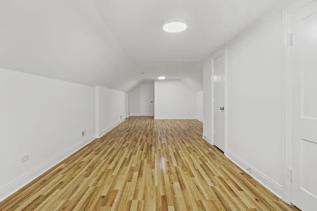 a view of a room with wooden floor and white walls