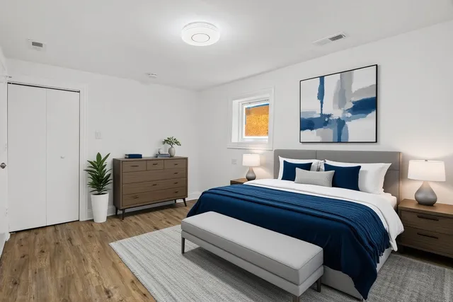 a bedroom with a bed and painting on the wall