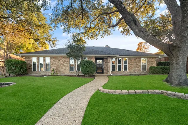 a front view of a house with a yard porch and wooden fence