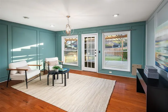 a dining room with wooden floor a glass table and chairs