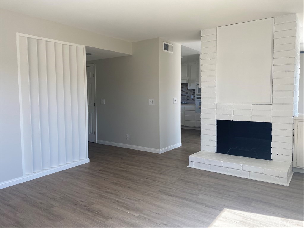 9132 Margate Circle Westminster, CA 92683 - Photo 8 of 16 an empty room with wooden floor fireplace and windows