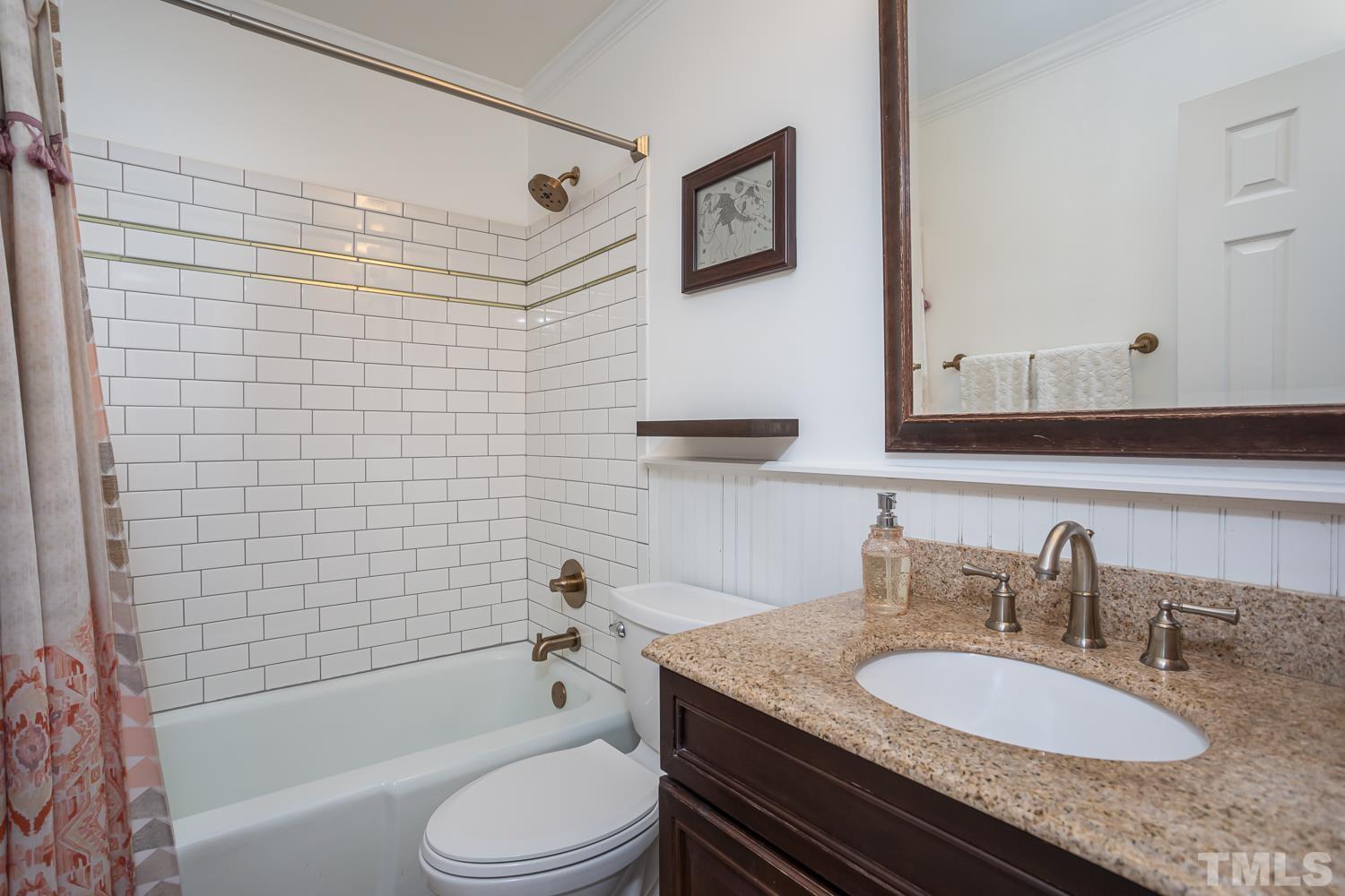 211 Plainview Avenue Raleigh, NC 27604 - Photo 22 of 39 a bathroom with a granite countertop toilet sink a mirror a bathtub and shower