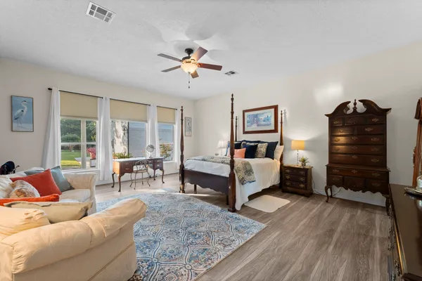 a bedroom with a bed and wooden floor