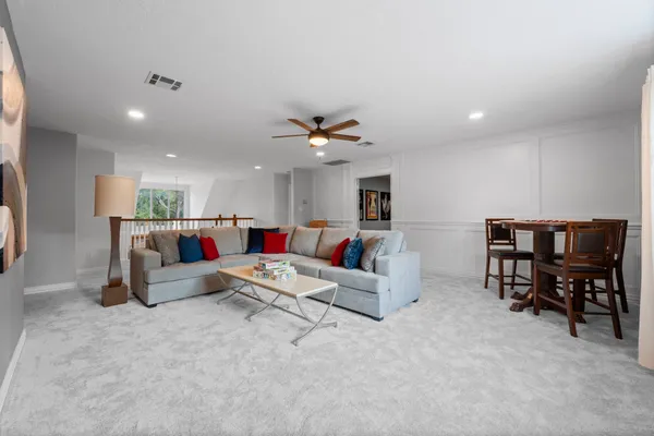 a living room with furniture and ceiling fan