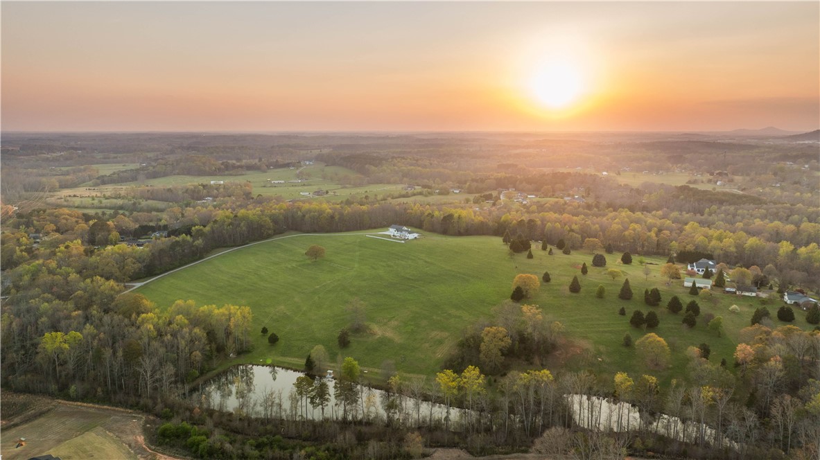 331 Bakerville Road Easley, SC 29642 - Photo 3 of 43 Expansive green acreage with private pond offers serene country living at sunset.