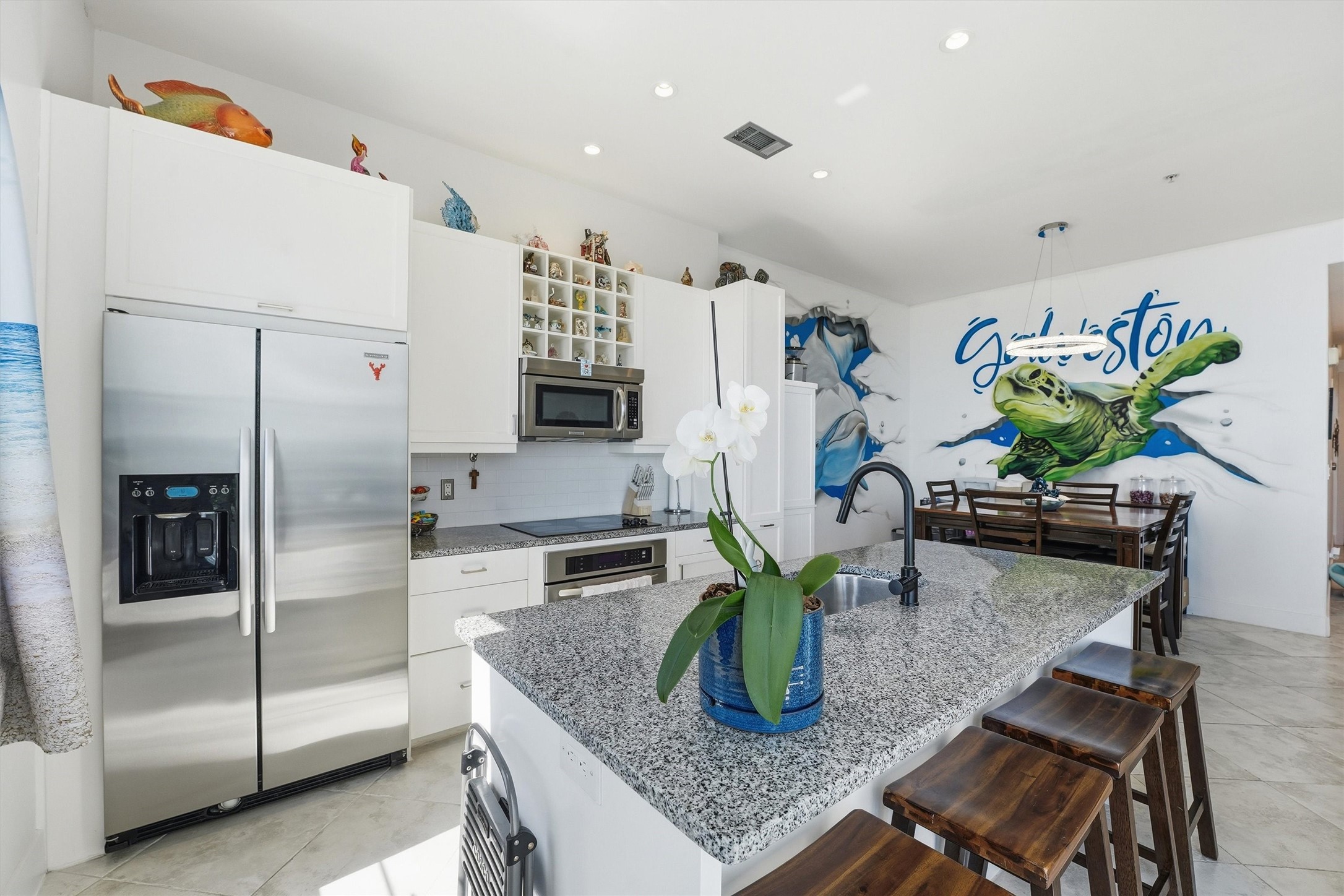 10327 Termini-San Luis Pass Road, Unit 616 Galveston, TX 77554 - Photo 6 of 38 a kitchen with stainless steel appliances granite countertop sink table and chairs