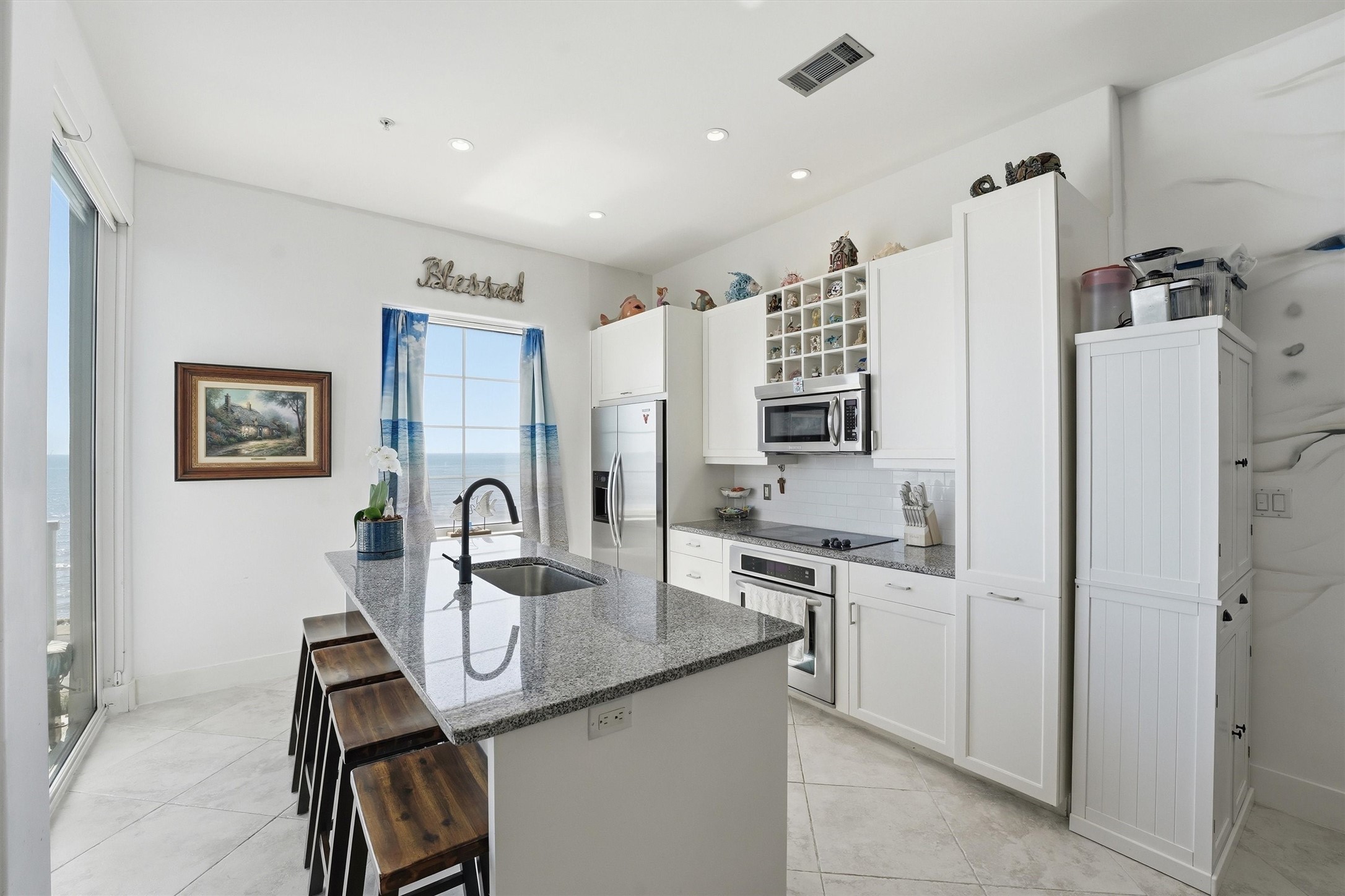 10327 Termini-San Luis Pass Road, Unit 616 Galveston, TX 77554 - Photo 7 of 38 a kitchen with stainless steel appliances granite countertop a refrigerator and a stove top oven