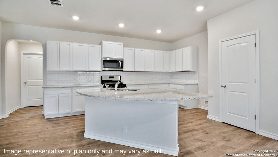 5019 Rancagua Converse, TX 78109 - Photo 6 of 35 a kitchen with stainless steel appliances granite countertop a sink a stove a refrigerator and white cabinets