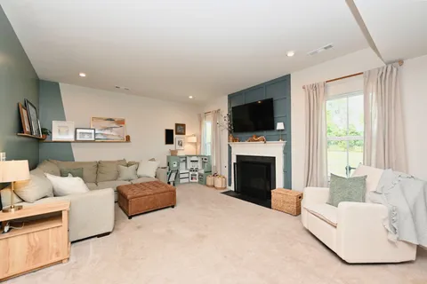 a living room with furniture a fireplace and a flat screen tv
