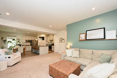 a living room with furniture and kitchen view
