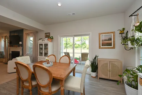 a dining room with furniture potted plants and wooden floor