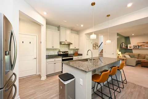 a kitchen with stainless steel appliances granite countertop a stove refrigerator and cabinets