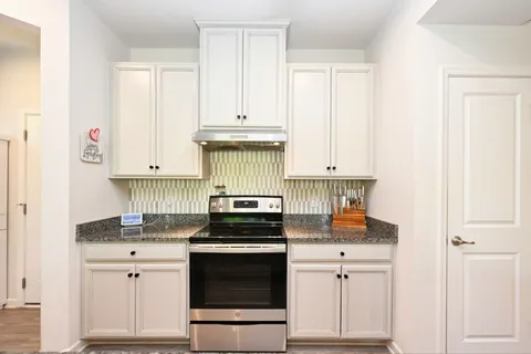 a kitchen with white cabinets and appliances