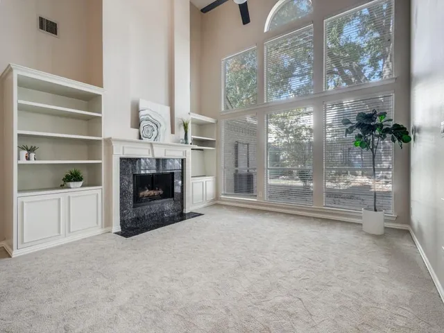 a view of an empty room with a fireplace and a window
