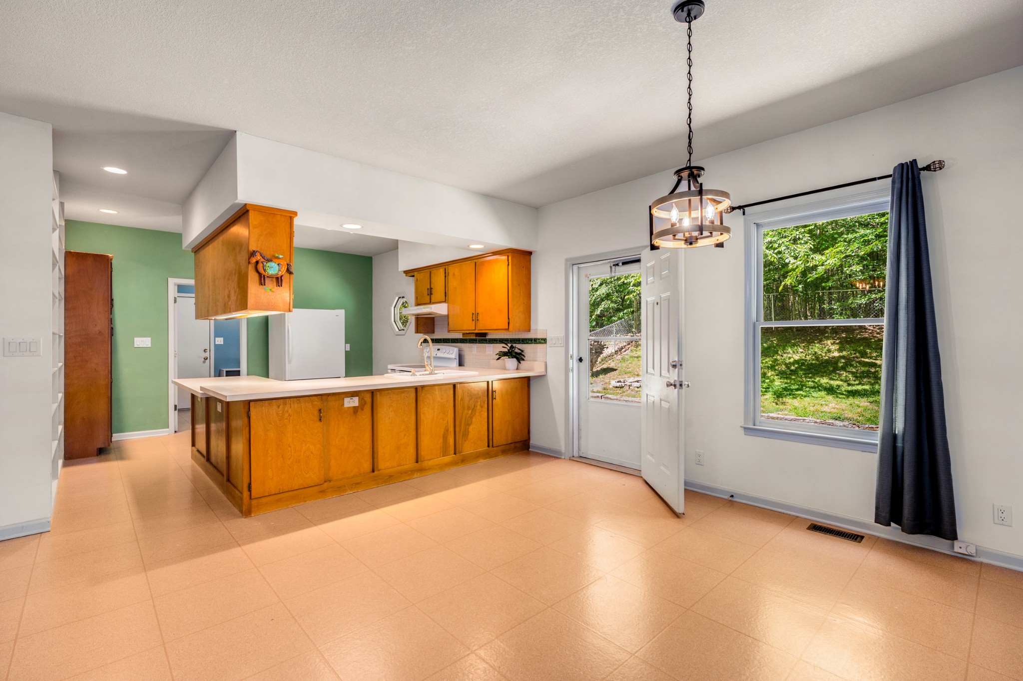 358 Harper Road Clarksville, TN 37043 - Photo 9 of 34 a view of a kitchen with kitchen island a large window cabinets a sink and stainless steel appliances